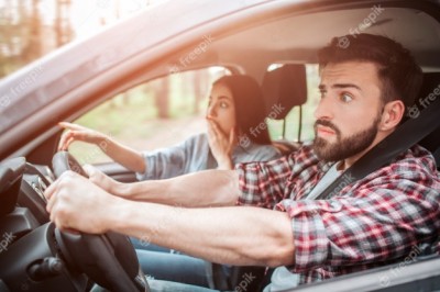 amazed-people-are-sitting-in-car-and-looking-straight-forward-they-are-frustrated-girl-is-covering-her-mouth-with-one-hand-and-pointing-forward-with-another-one_152404-9533.jpg